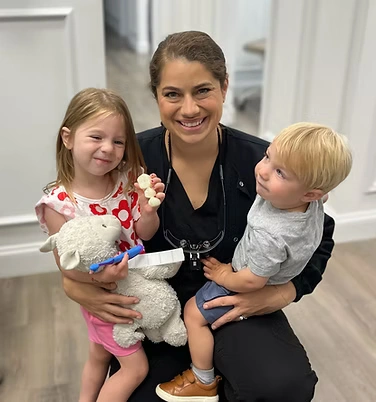 Dr. McMahon smiling with two happy children