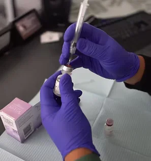 Dental professional in purple gloves preparing a Botox injection at The Hamptons Dentist in Westhampton Beach NY