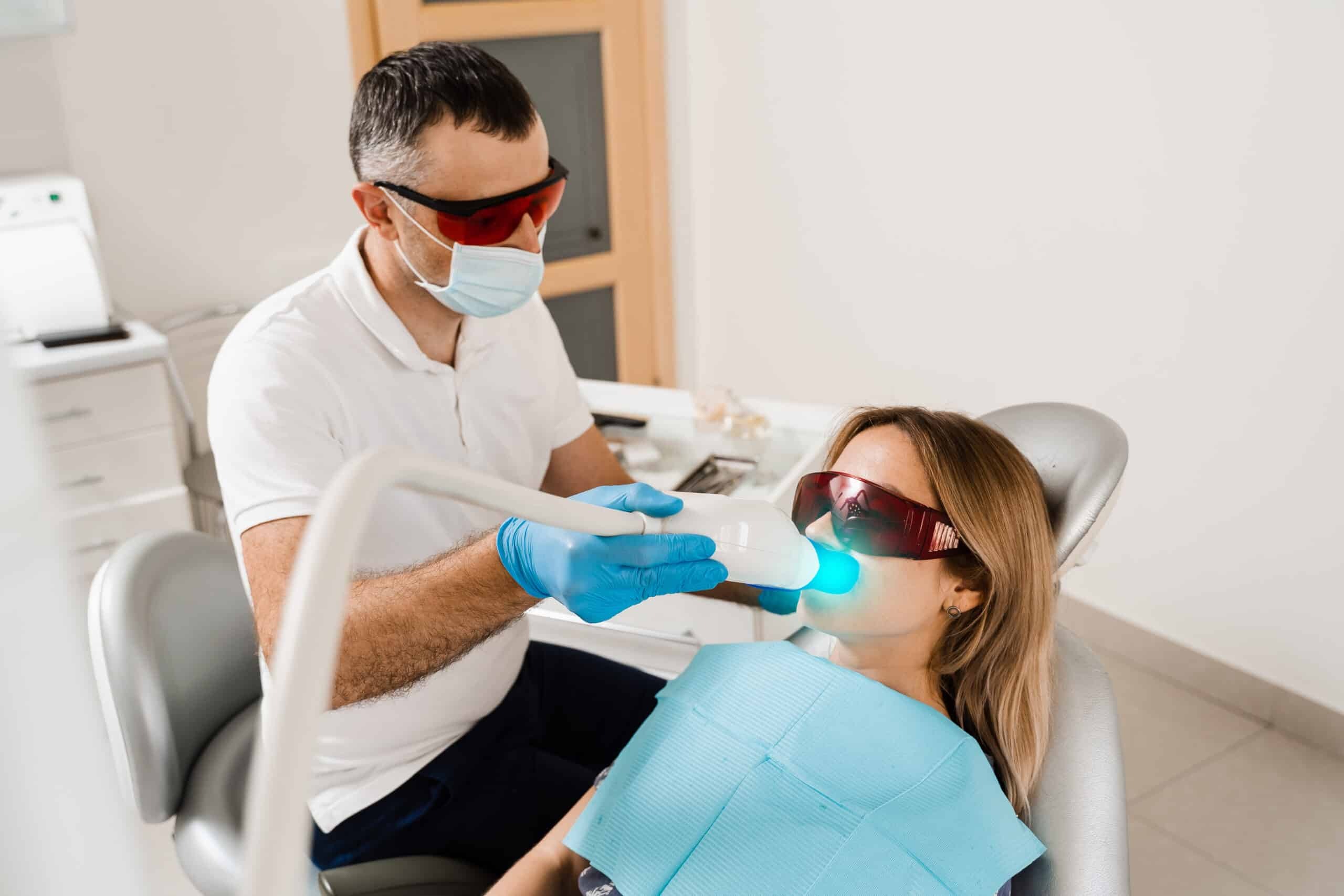 Dentist applying professional teeth whitening treatment to patient in Westhampton Beach.
